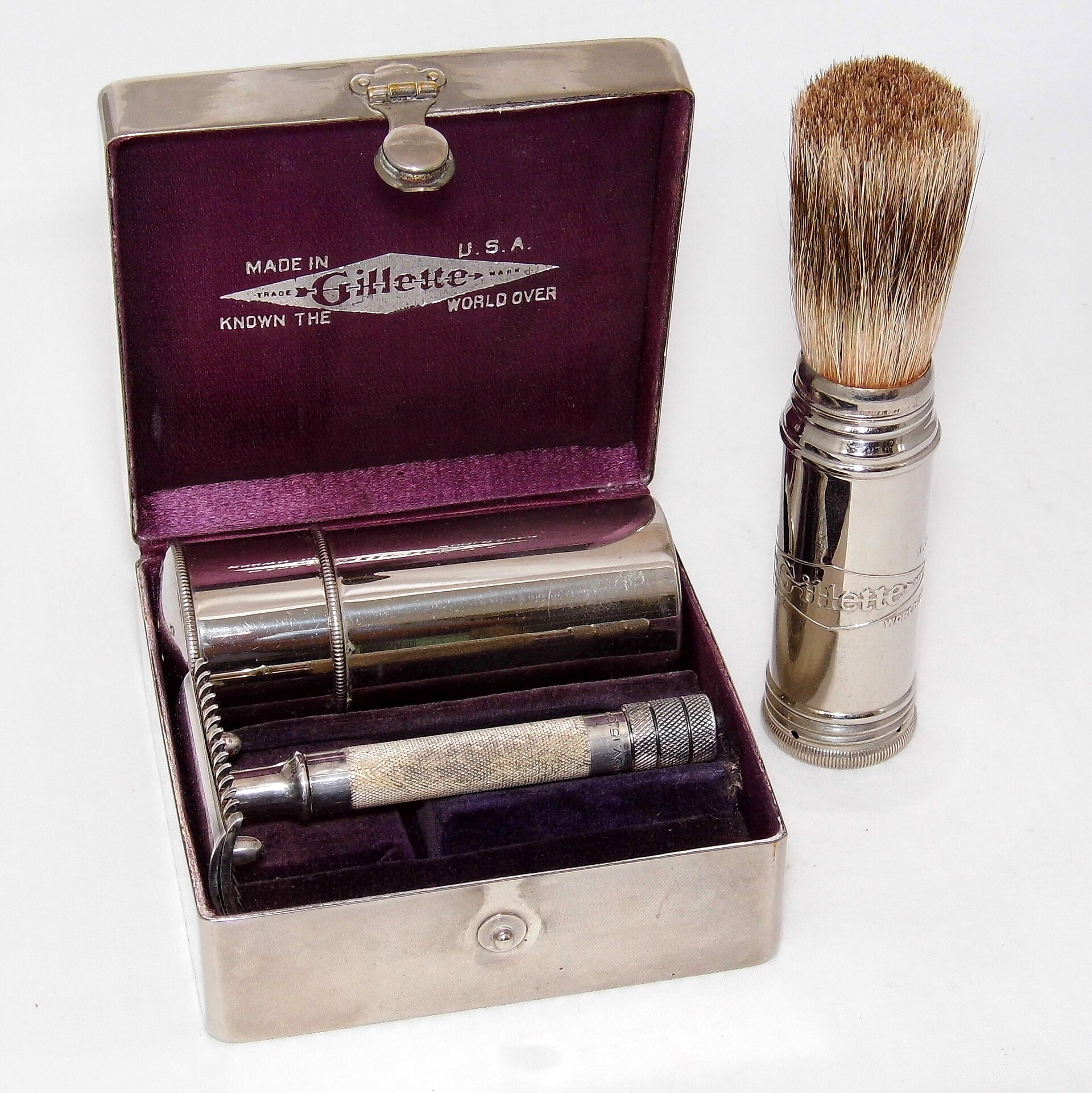 A vintage safety razor and travel brush in a cased set